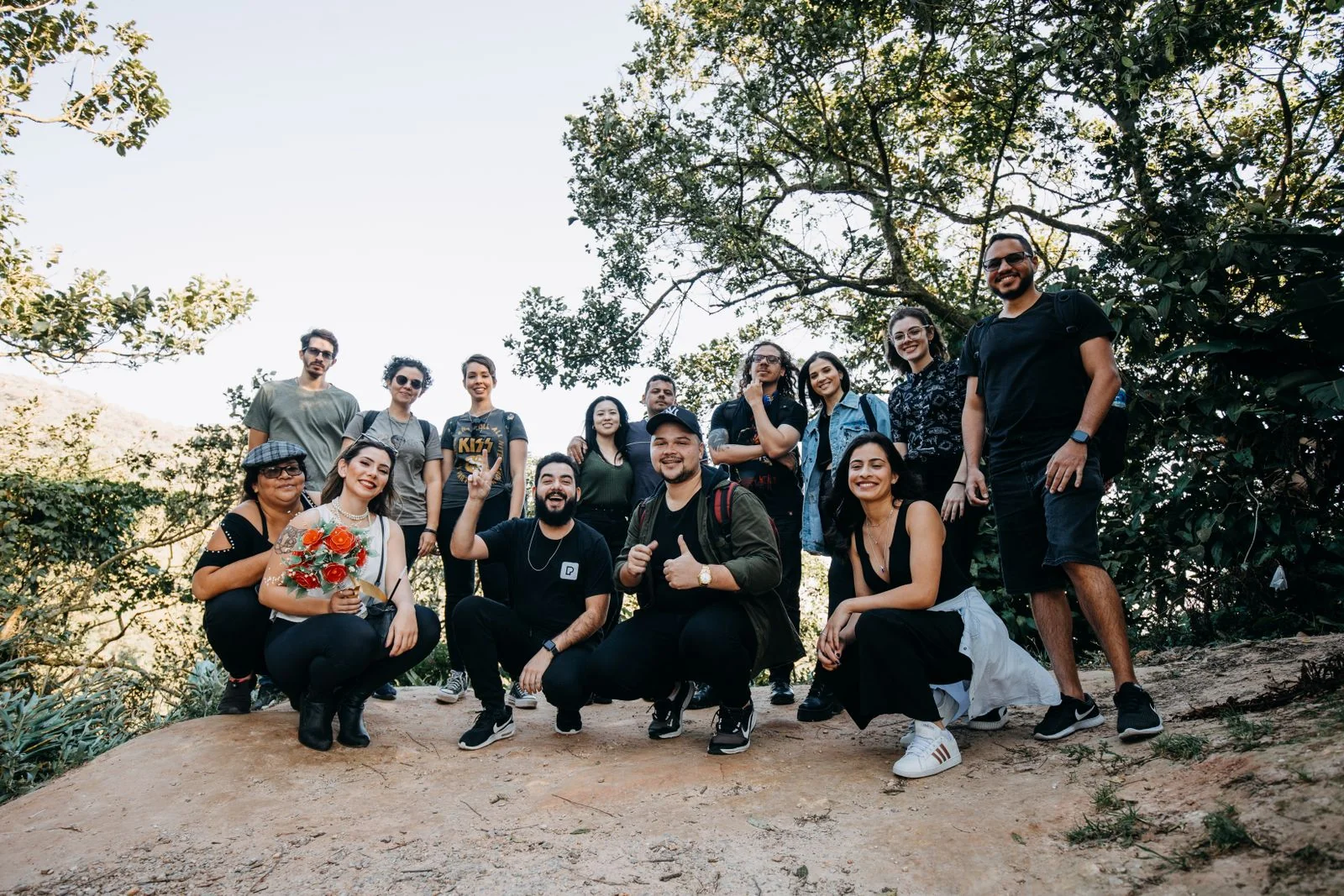 Diverse group of friends smiling and posing together during a trek in the forest